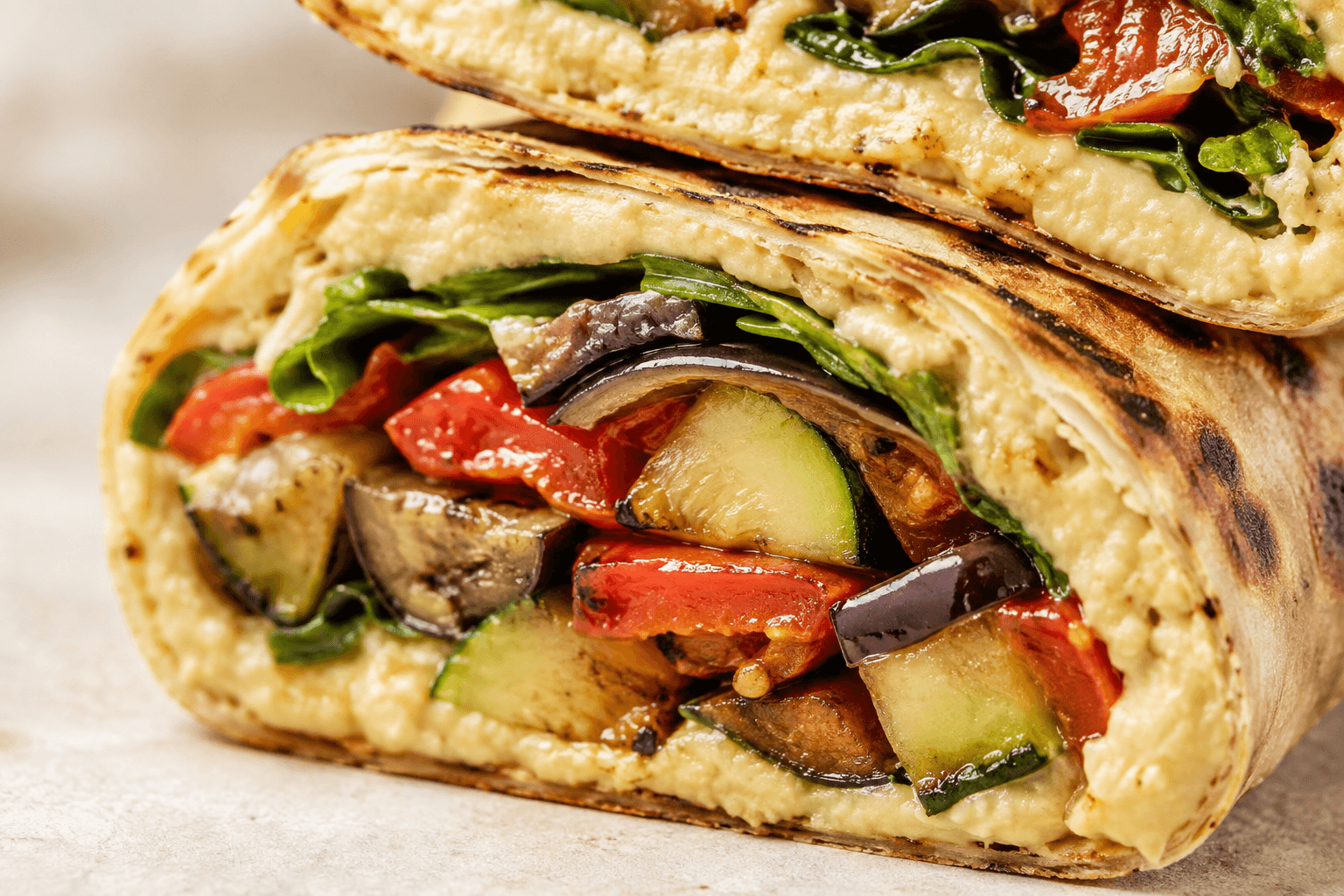 Close-up van hummus, courgette, paprika en aubergine in een wrap