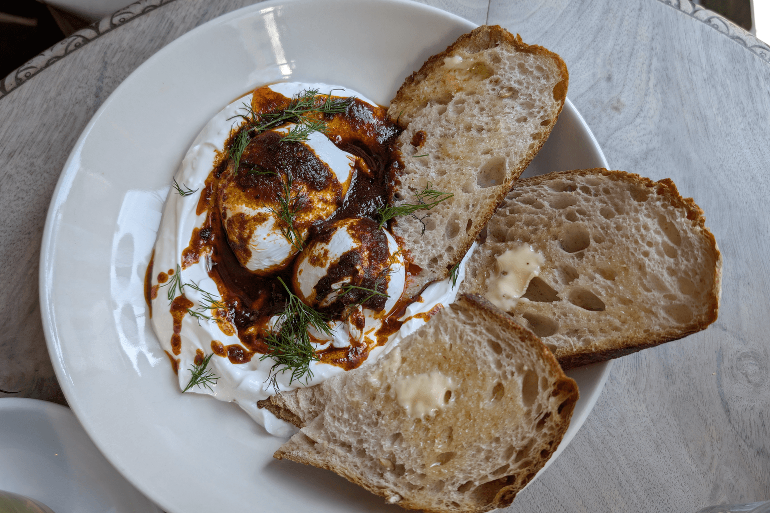 Close-up van gepocheerde eieren met yoghurt en chiliboter