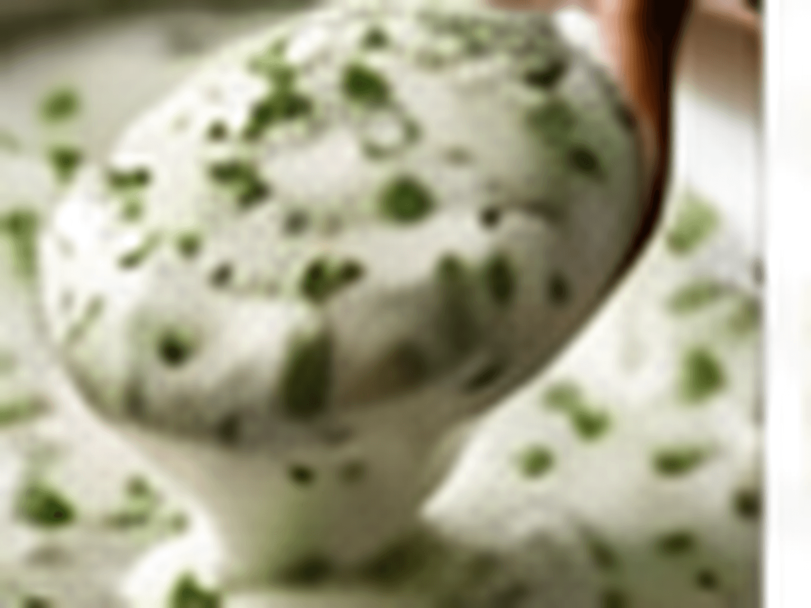 Close-up van yoghurt-muntdressing met verse kruiden