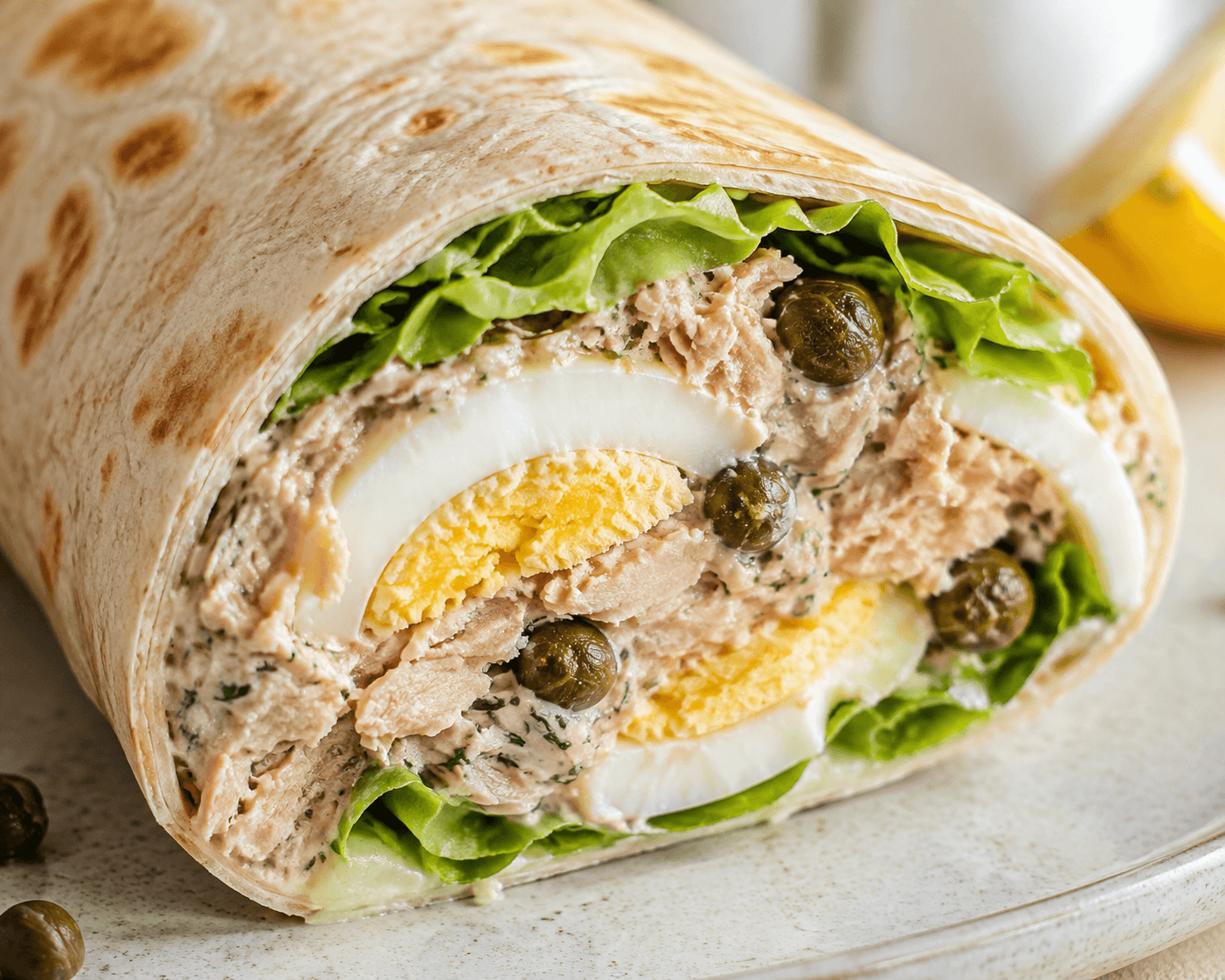 Close-up van Fris-romige tonijnwrap met ei en kappertjes